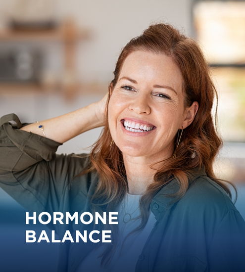 Smiling woman with red hair promoting hormone balance.