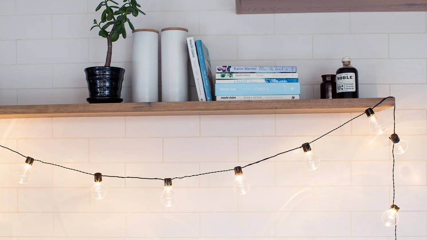 Warm white essential series festoons illuminated and draped across shelf