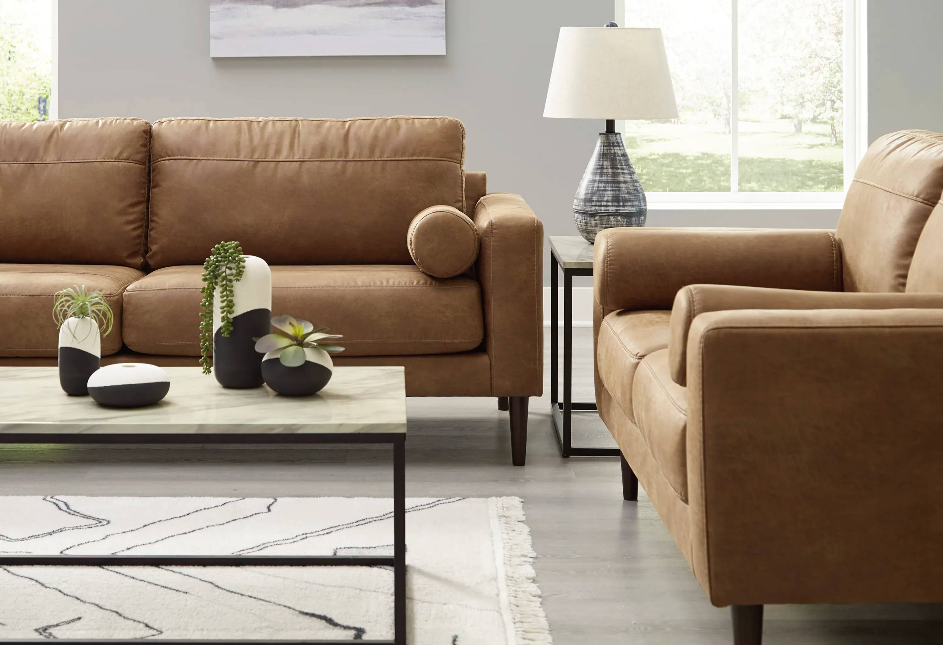Living room with brown sofas, a coffee table, and a lamp.