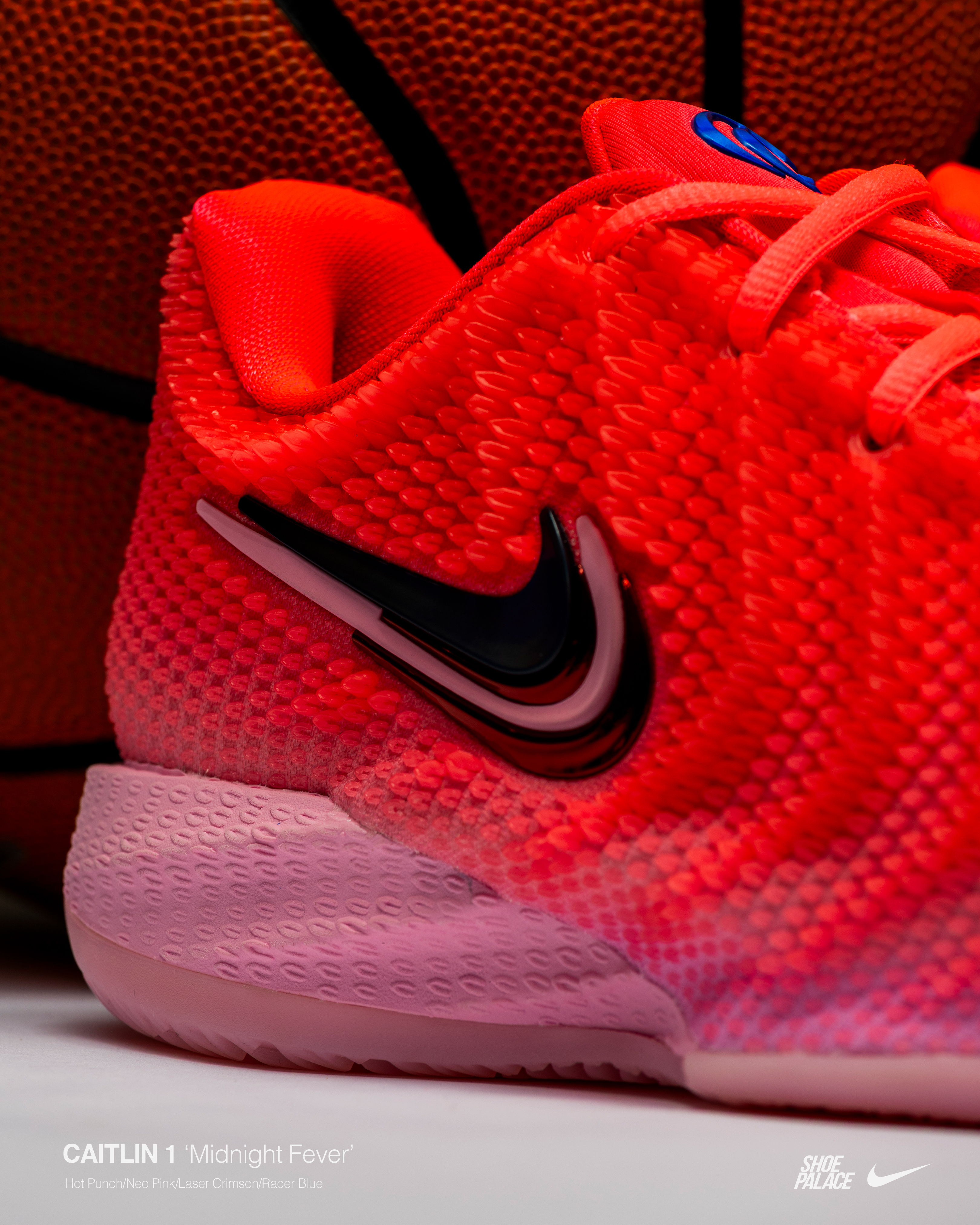 Close-up of a red Nike shoe with a basketball in the background.