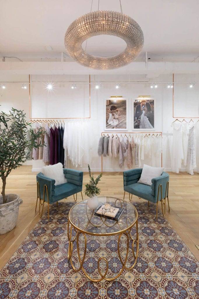 Waiting area on bridal shop with large chandelier and velvet couches 