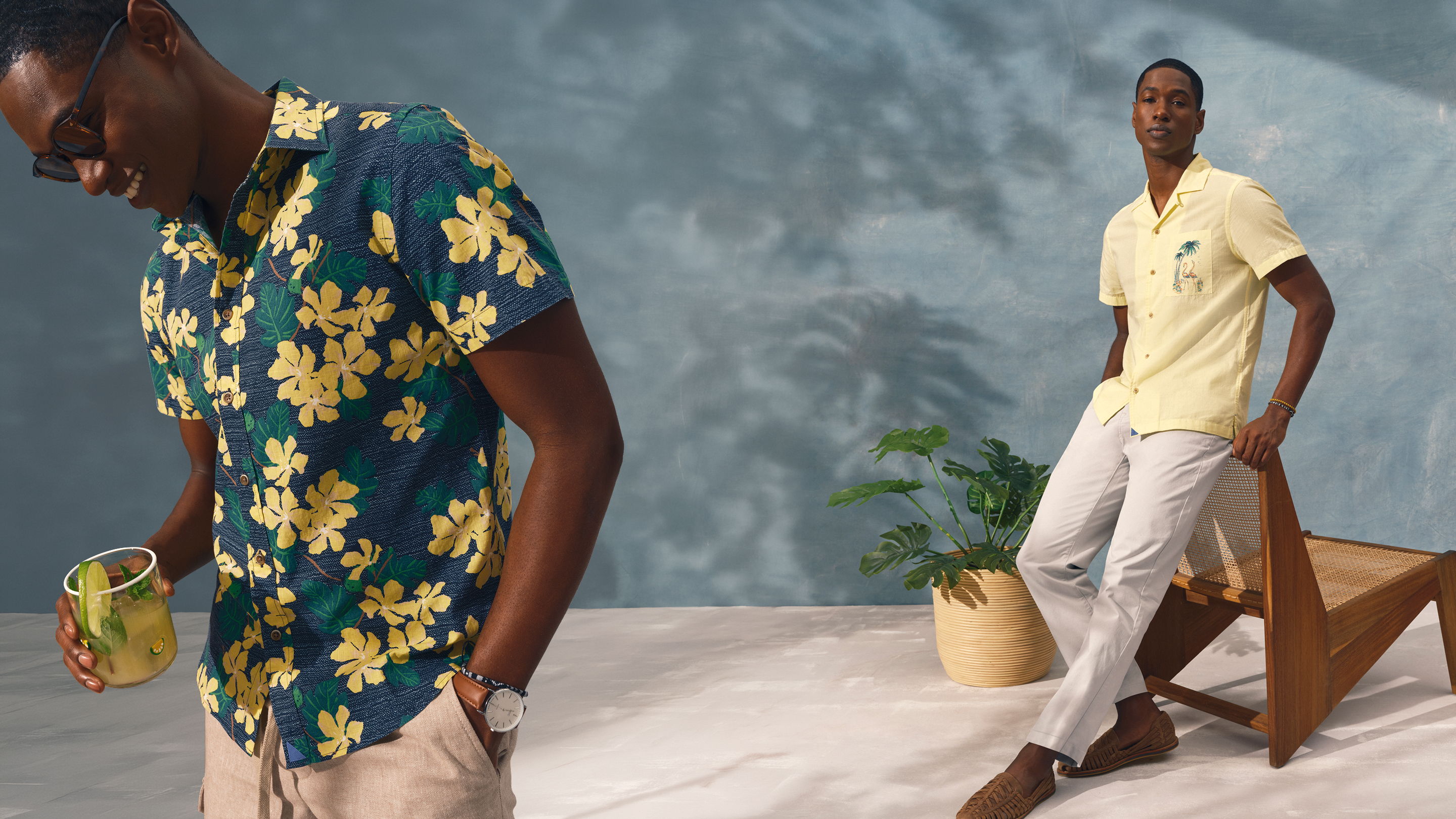 Two men in stylish summer outfits with tropical patterns and casual poses.