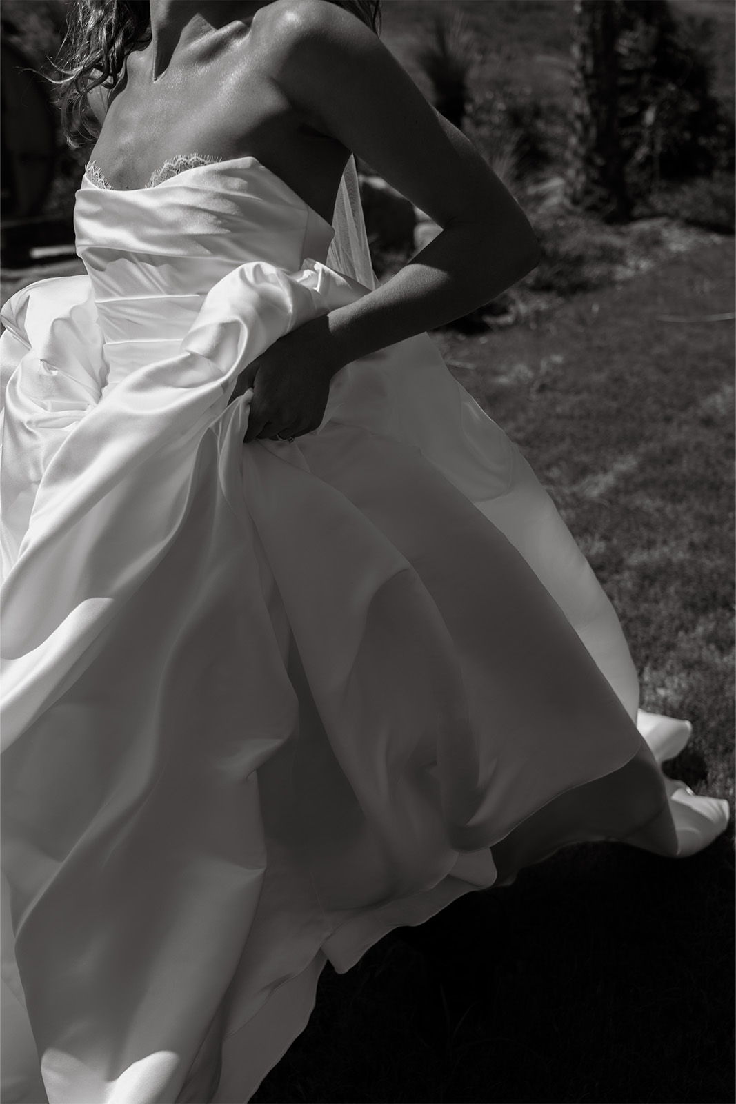 A woman in a wedding dress outdoors, in black and white.