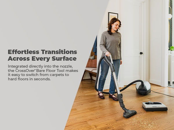 Woman vacuuming a wooden floor with a vacuum cleaner.
