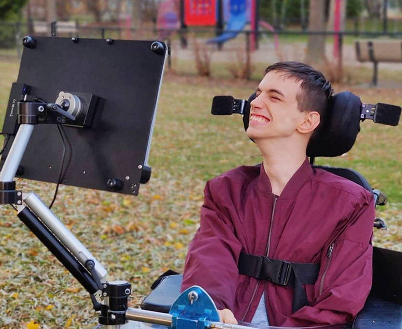 Man using Tobii Dynavox assistive technology while outdoors