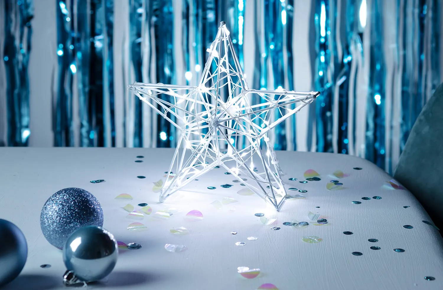 white star battery Christmas light on table top with confetti