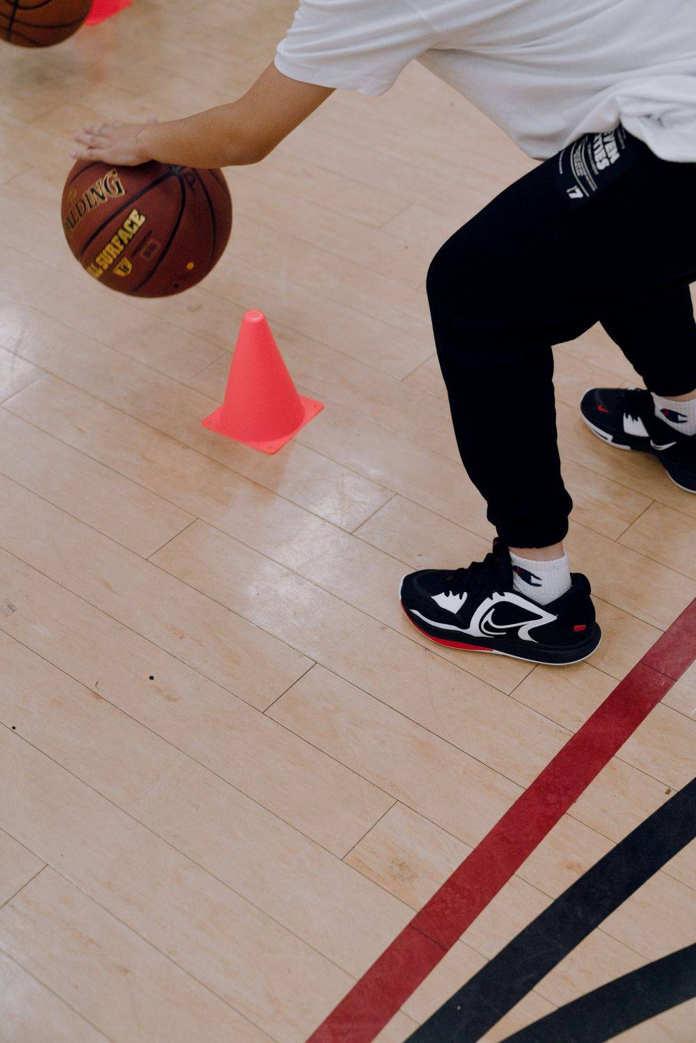 kid dribbling between cones