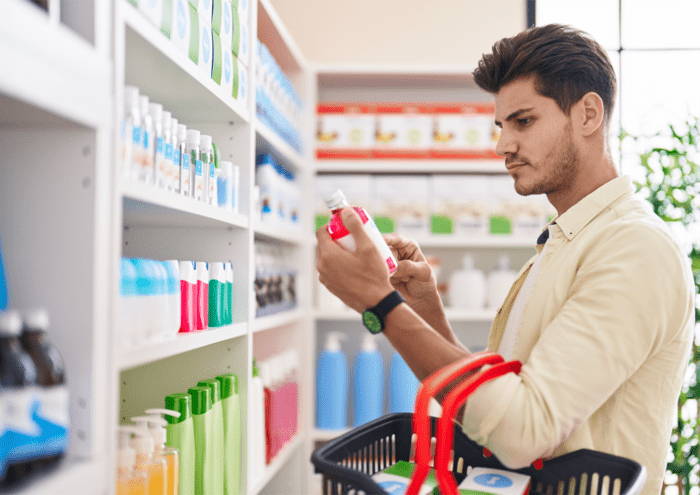 Customer reading product label in pharmacy