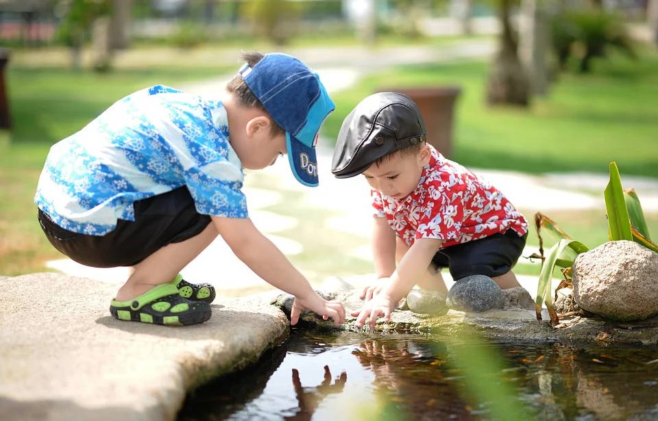 Image of two children pointing at something in a pond.