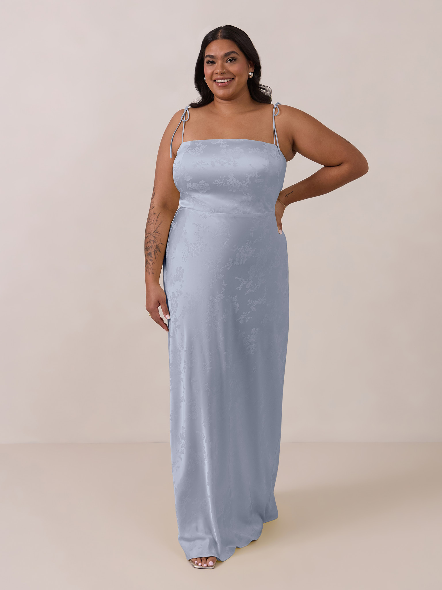 Model in a light blue evening gown against a neutral background.