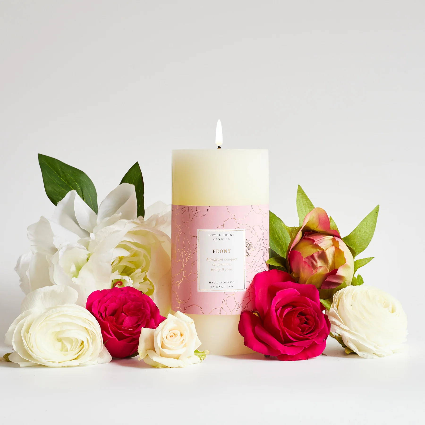Eucalyptus & Mint Luxury scented candle from Lower Lodge Candles Colour Pop! collection pictured with its cardboard tube packaging against a pastel pink background with eucalyptus leaves