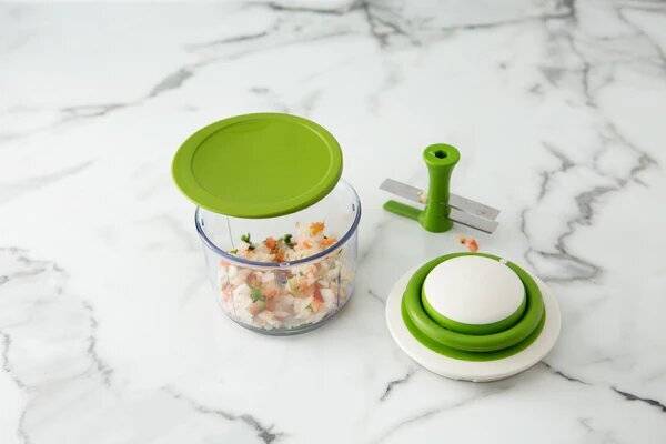 A vegetable chopper with food in it.