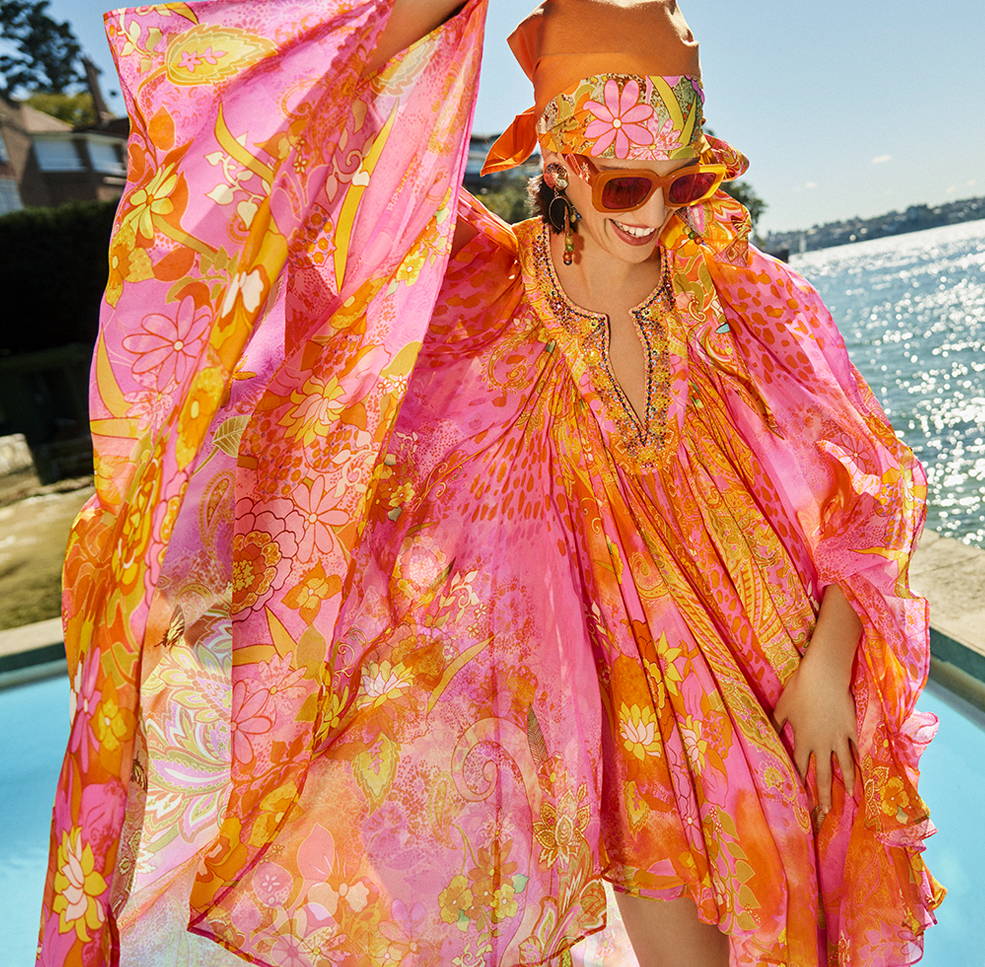 Model in CAMILLA fluro orange and pink kaftan by pool