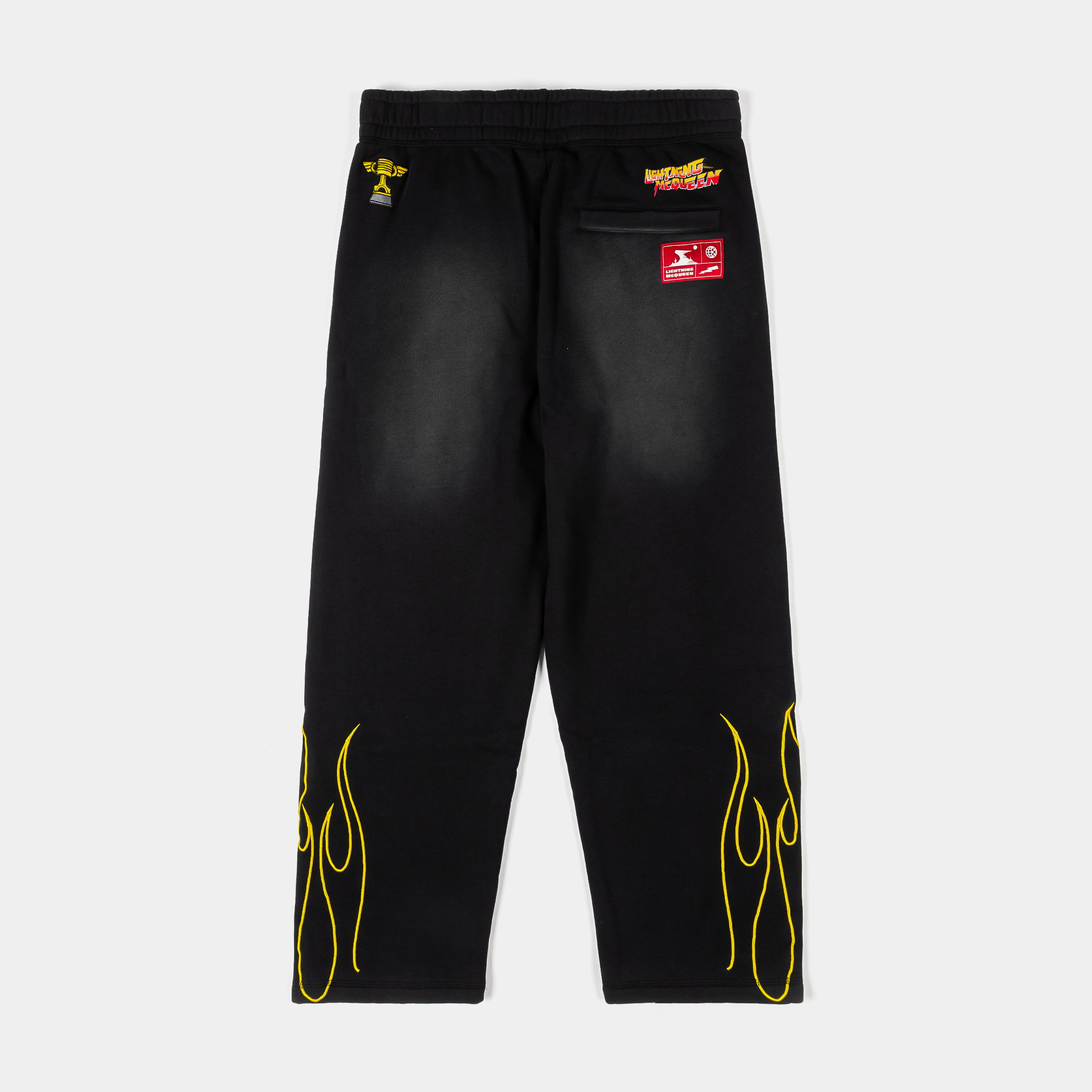 Black pants with yellow flame design and graphic text on the front.