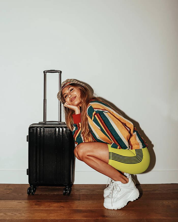 Alyssa with her CALPAK Ambeur Carry-On Luggage in Black.