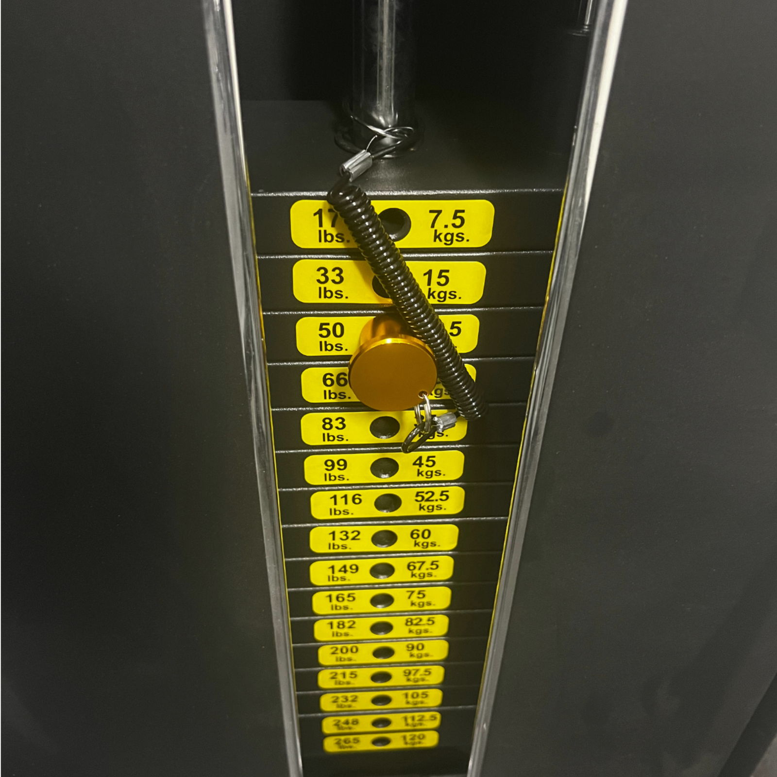 Weights stack on a gym machine with labeled increments.