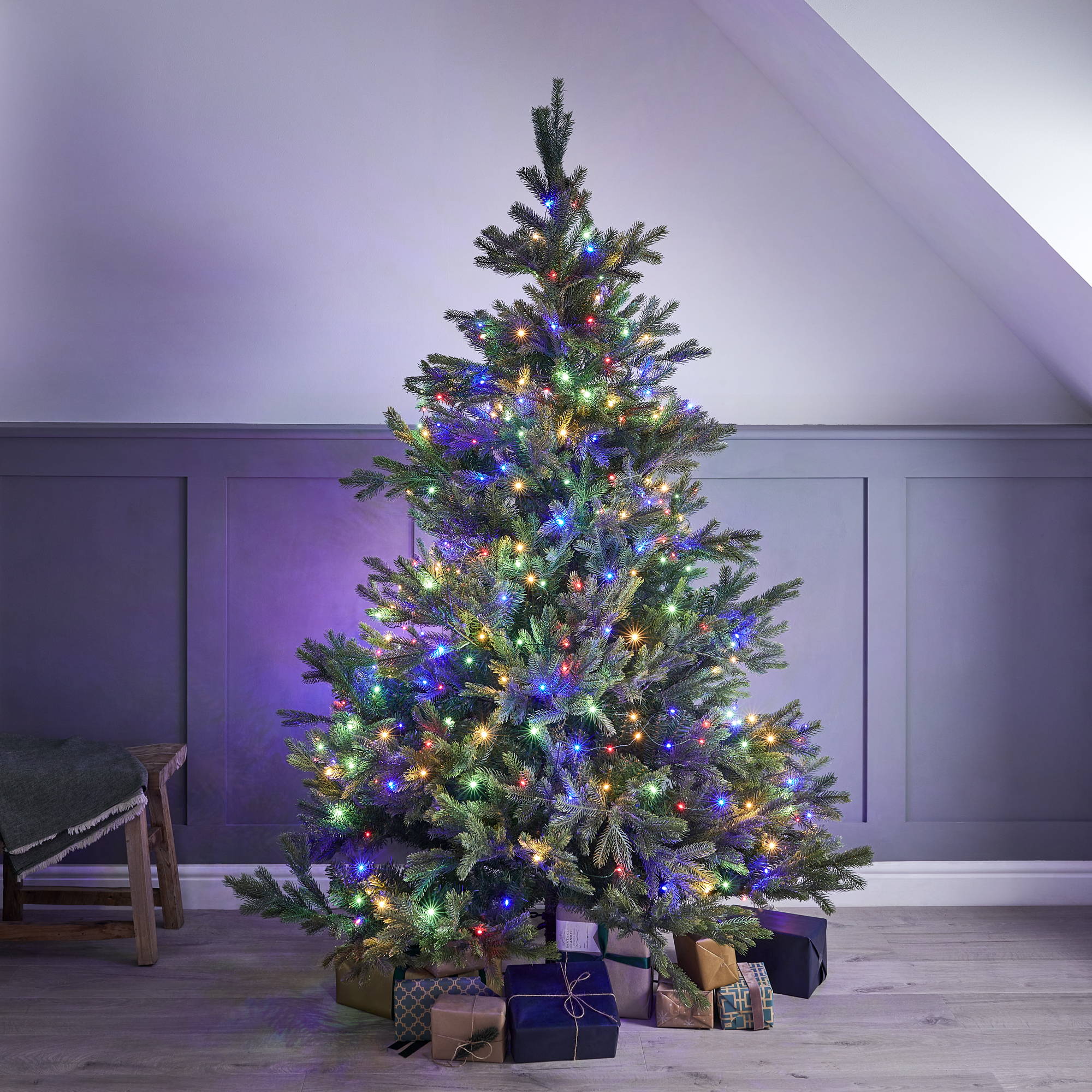 Christmas tree with multicoloured lights and presents at the bottom.