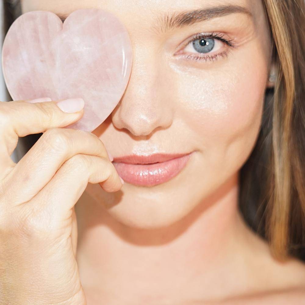 Miranda Kerr covering one eye with the Heart Facial Sculptor