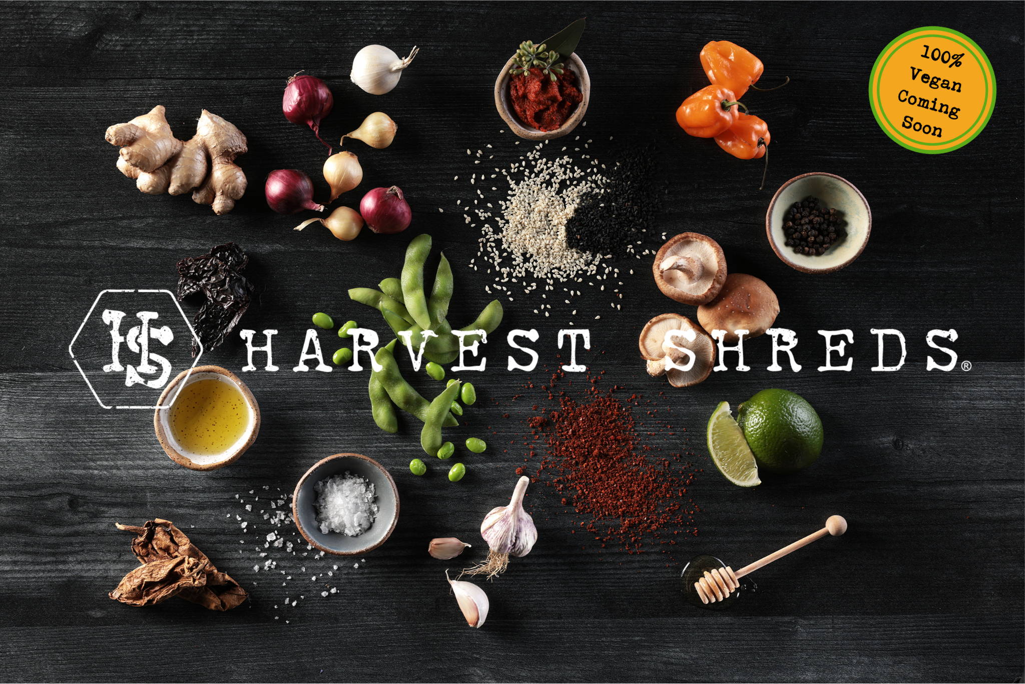 Harvest Shreds logo on a background of the components that make up this shredded plant protein, including chipotle peppers, garlic, salt, shiitake mushrooms, honey, ginger, sesame seeds, habanero peppers and red miso.