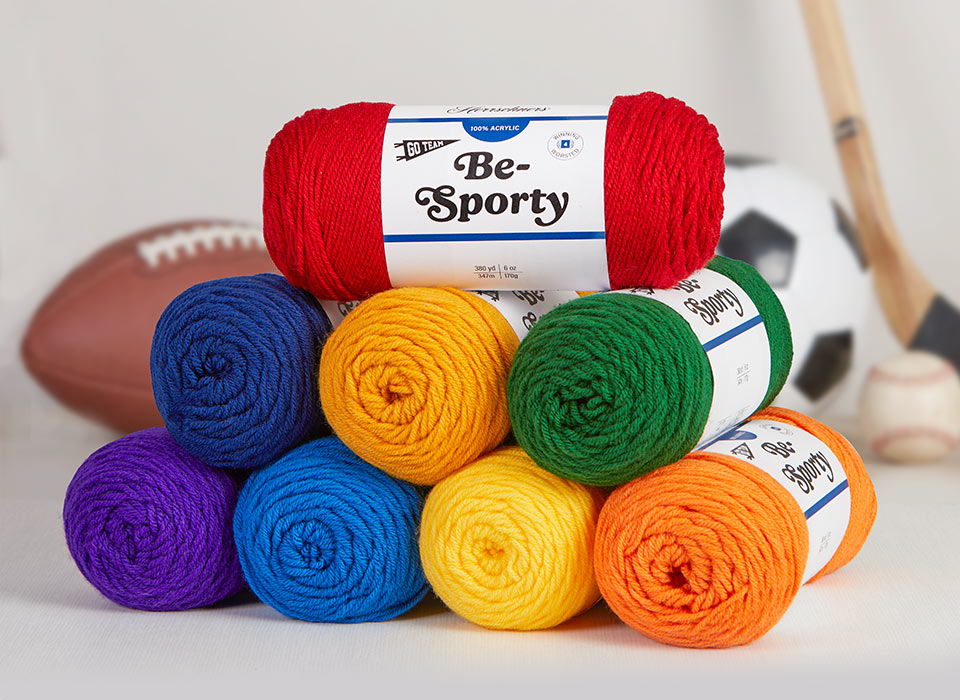 Colorful yarn spools stacked with sports equipment in the background.