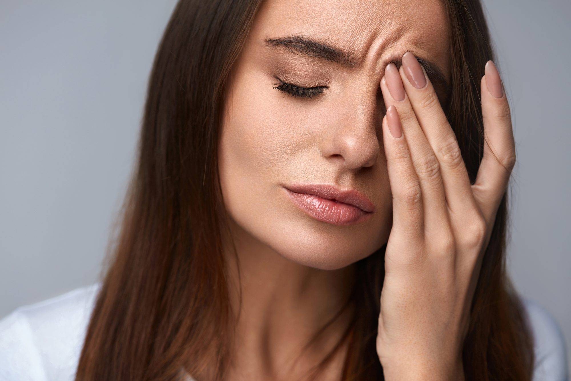Femme présentant des symptômes de fatigue oculaire et de maux de tête essayant de se frotter les yeux, se sentant mal à l'aise