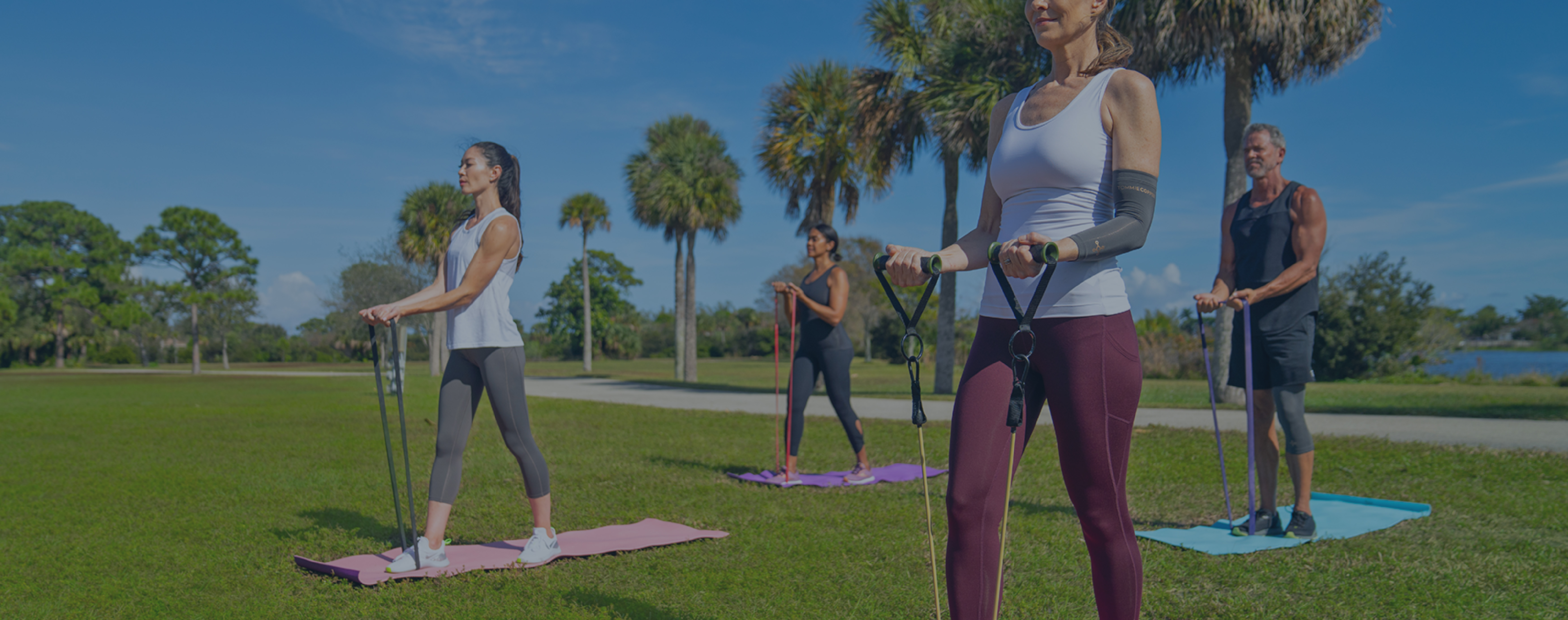 Group workout session in a park wearing Tommie Copper compression