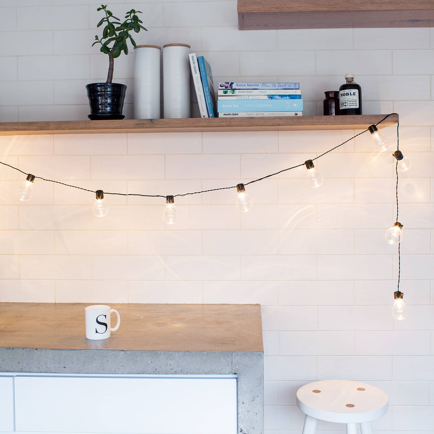 Festoon lights illuminated hung from shelf in kitchen