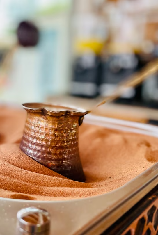 a metal container filled with sand next to a tree