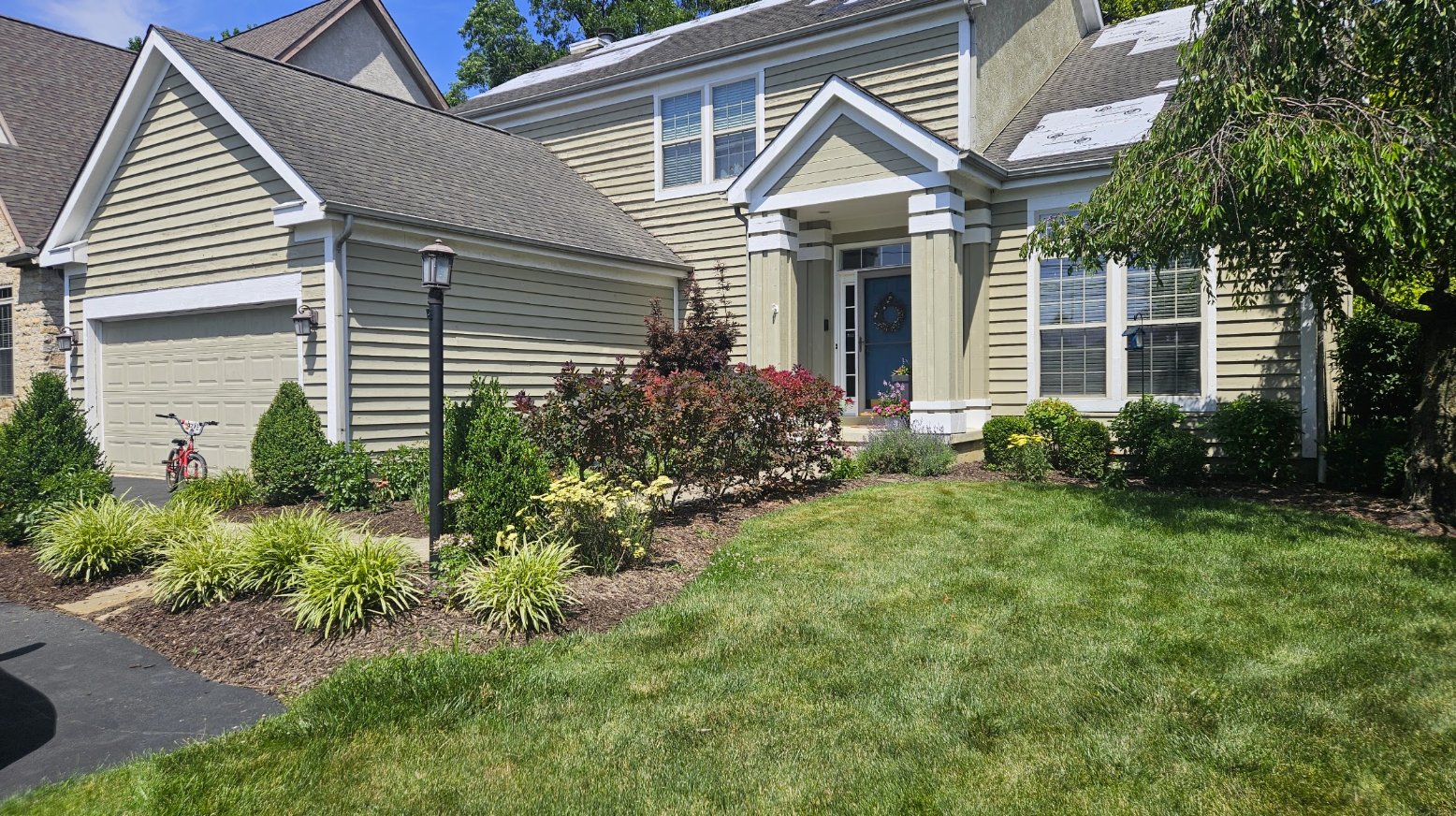 A well-maintained house with a landscaped yard and driveway.