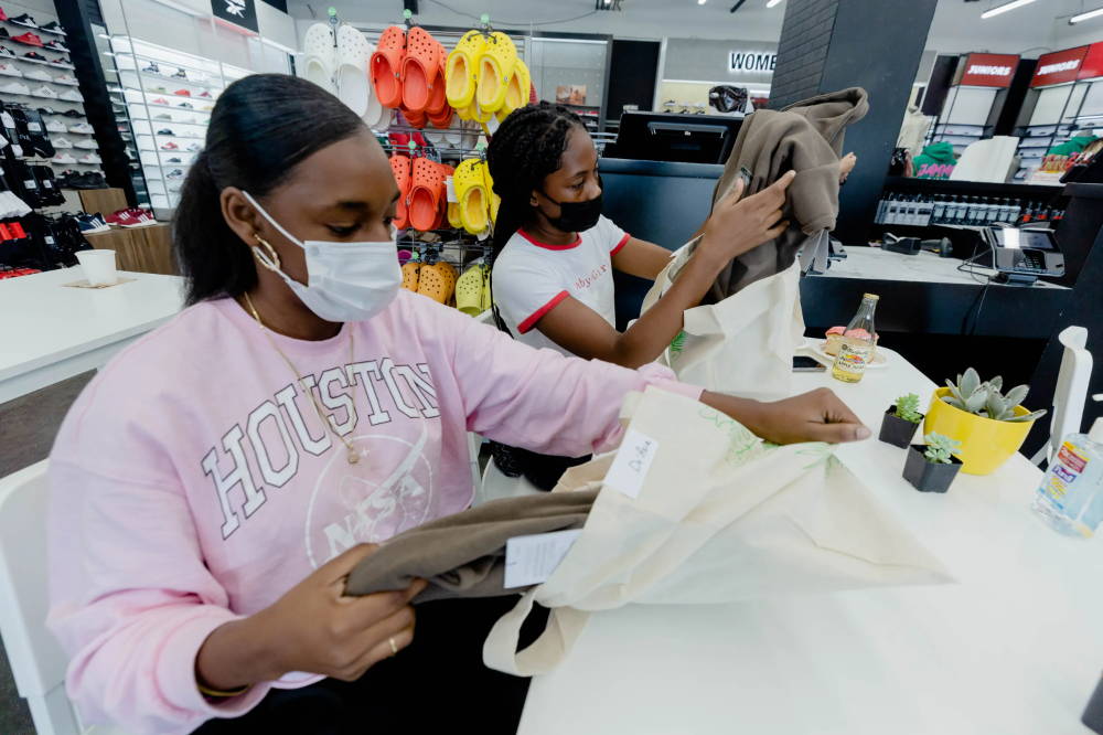 girls taking clothes out of bag at for her event