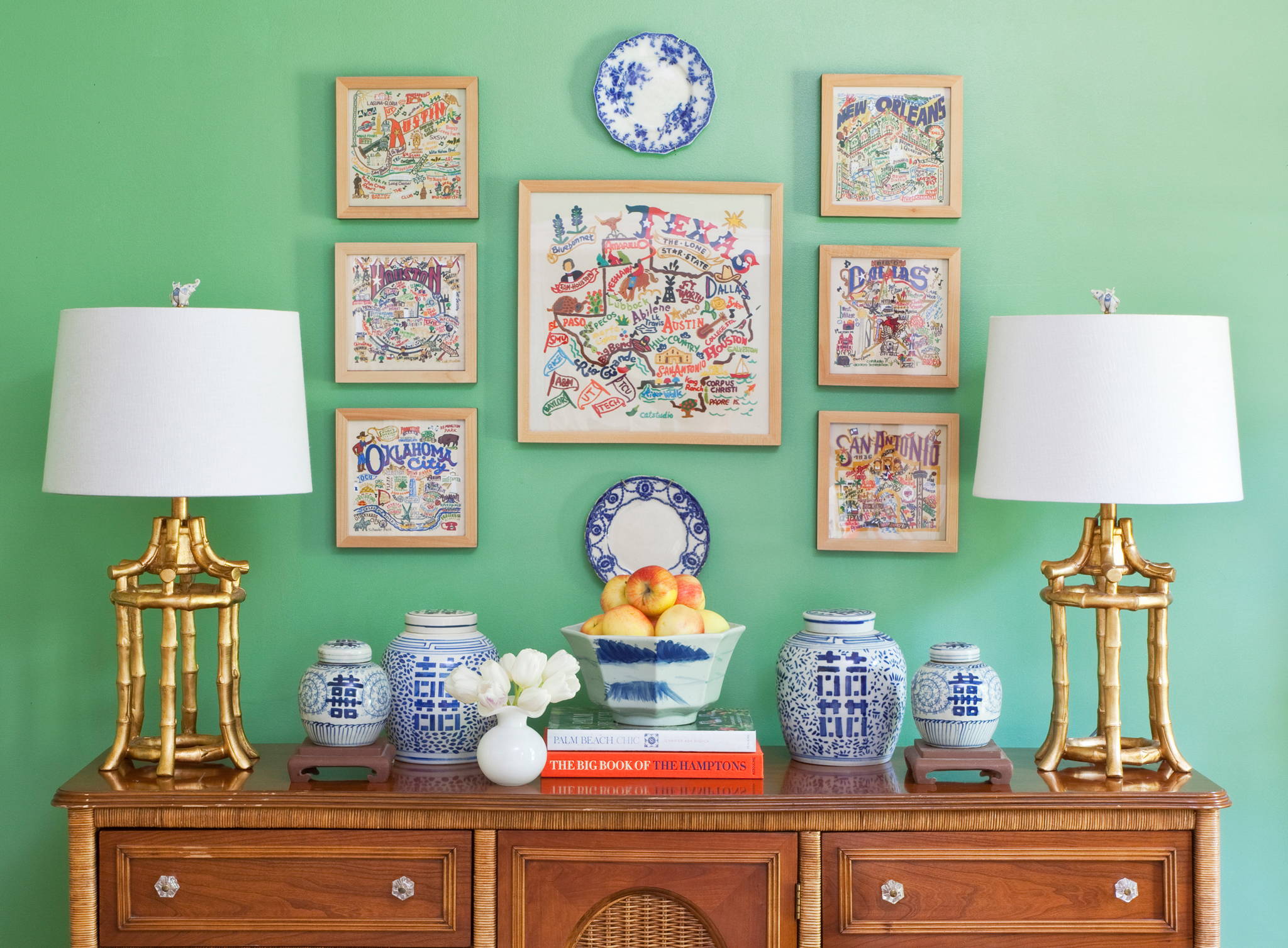 Group of Texas state and city art prints on green wall