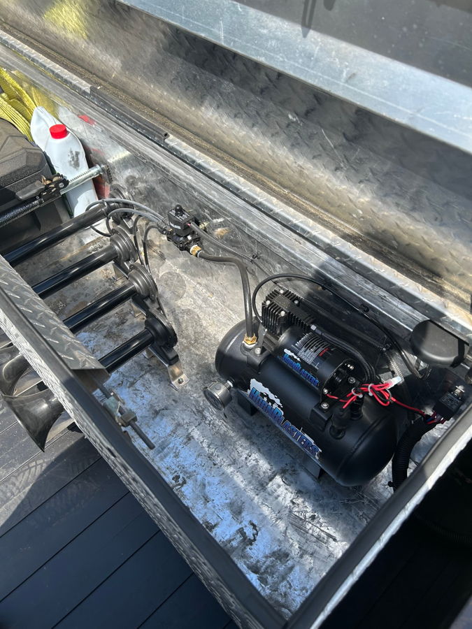 Overhead close-up HornBlasters air tank with compressor four black horn trumpets air lines and wiring inside diamond-plate toolbox Kyle's 1985 Chevy K20 Conductor's Special 127H gallery photo 4