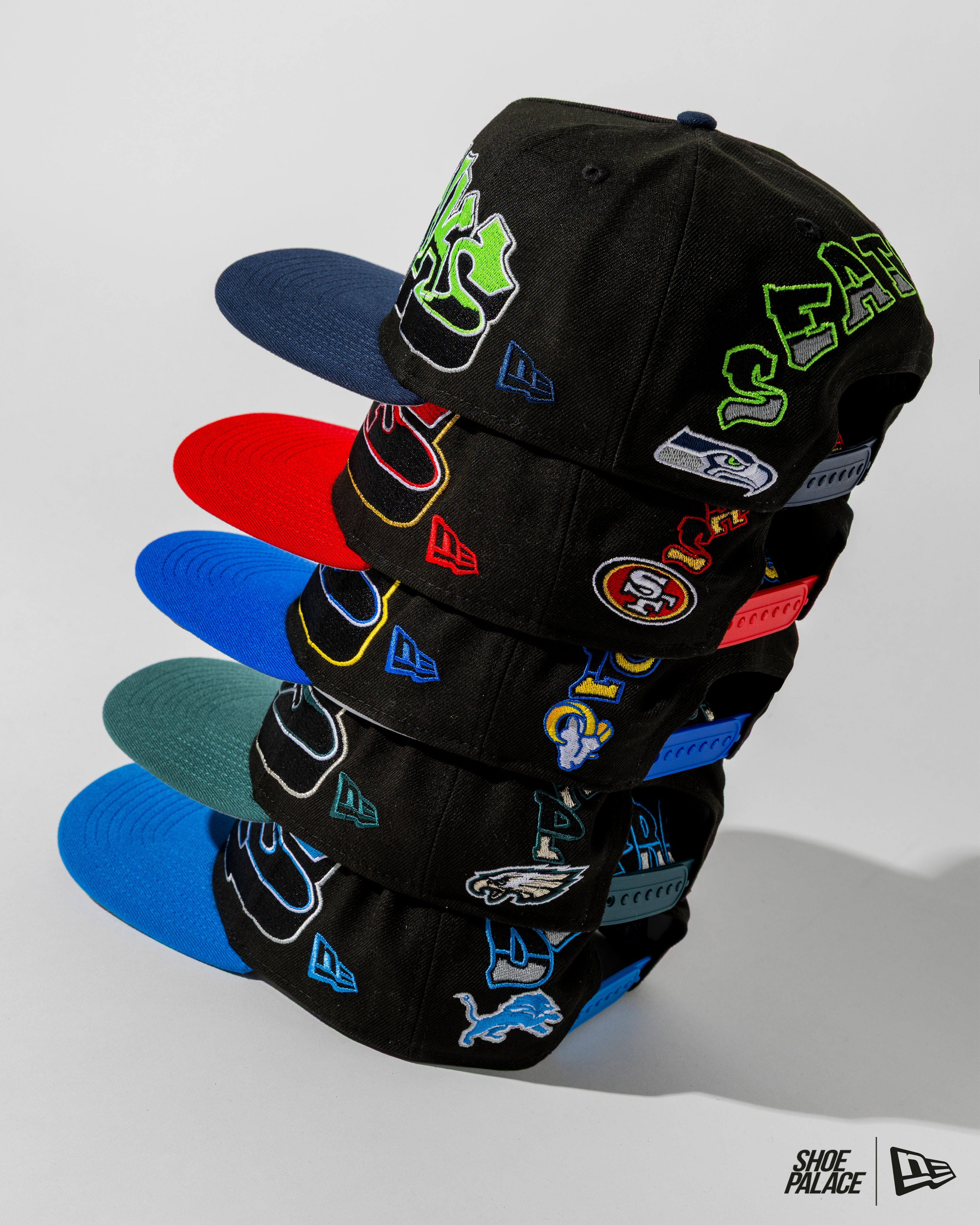 A stack of colorful baseball caps with various logos and designs.