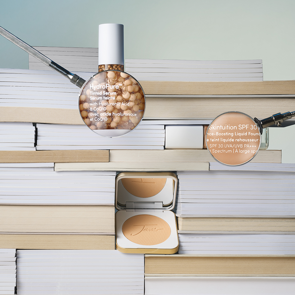 Bottles and magnifying glasses on a stack of books.