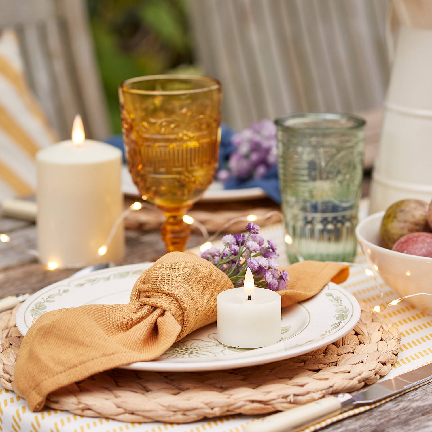 A place setting with LED candles, yellow accessories and fairy lights.