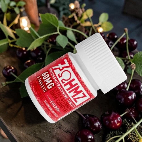 Bottle of 60mg gummies surrounded by cherries and greenery.