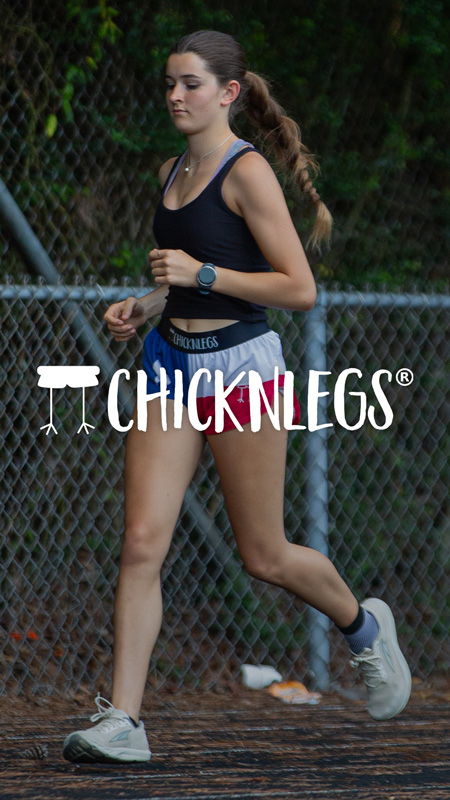 A young woman jogging on a track in athletic wear.