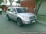 Front three-quarter Raymond's silver 2004 Toyota RAV4 aftermarket wheels tinted windows Conductor's Special 844K Nightmare Edition featured customer install gallery photo 1