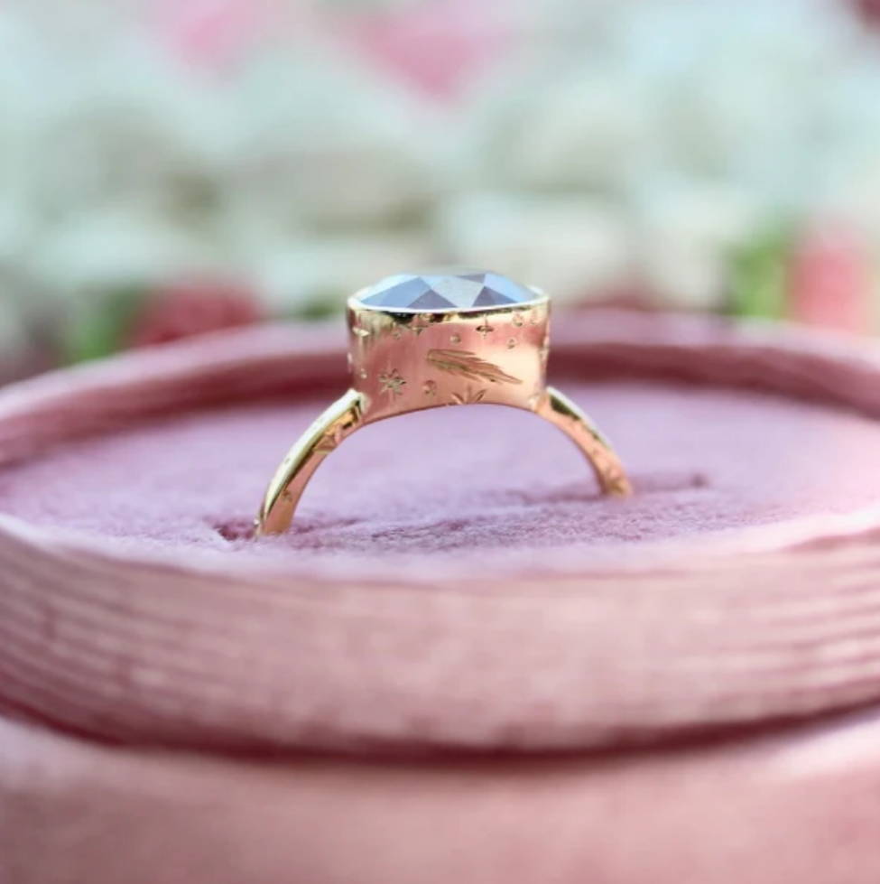 purple oval cut opalescent sapphire ring with cosmic engraving