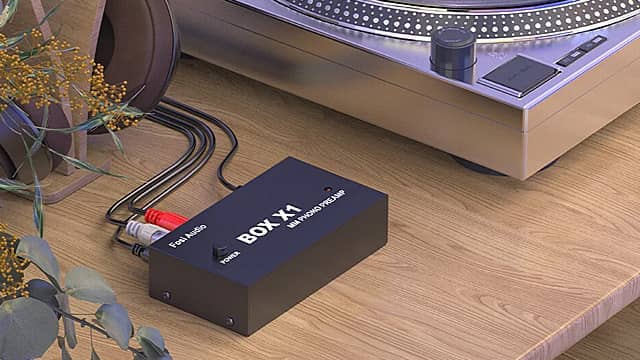 Audio interface connected to a turntable on a wooden surface.