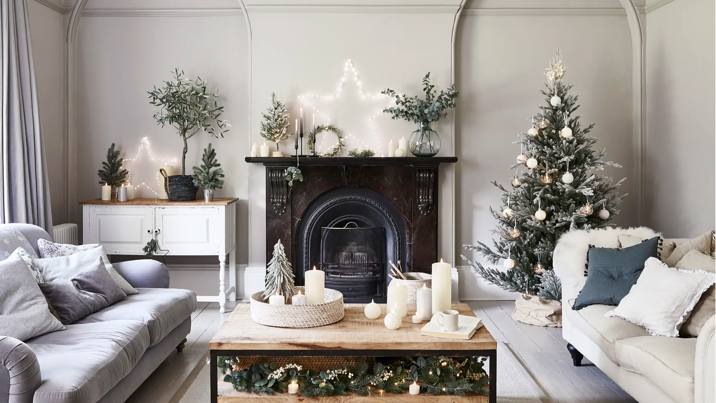 Christmas living room with a Christmas tree, star lights and candles.