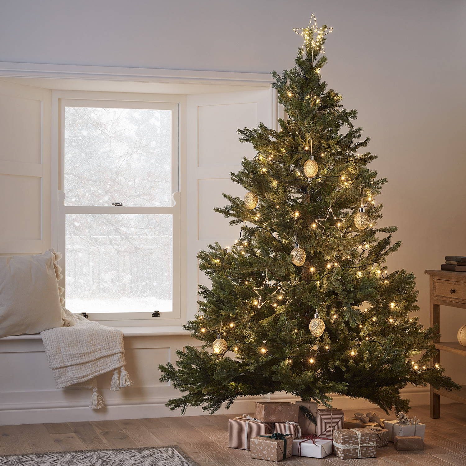 A cosy Christmas tree inside with gold warm white light up decorations.