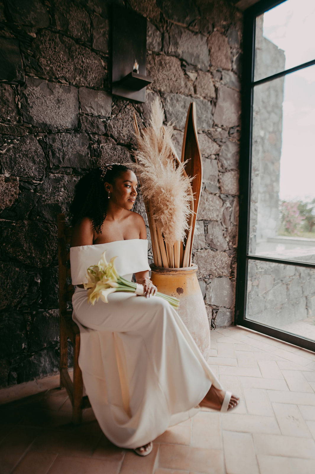 Bride sitting down holding bouquet of flowers