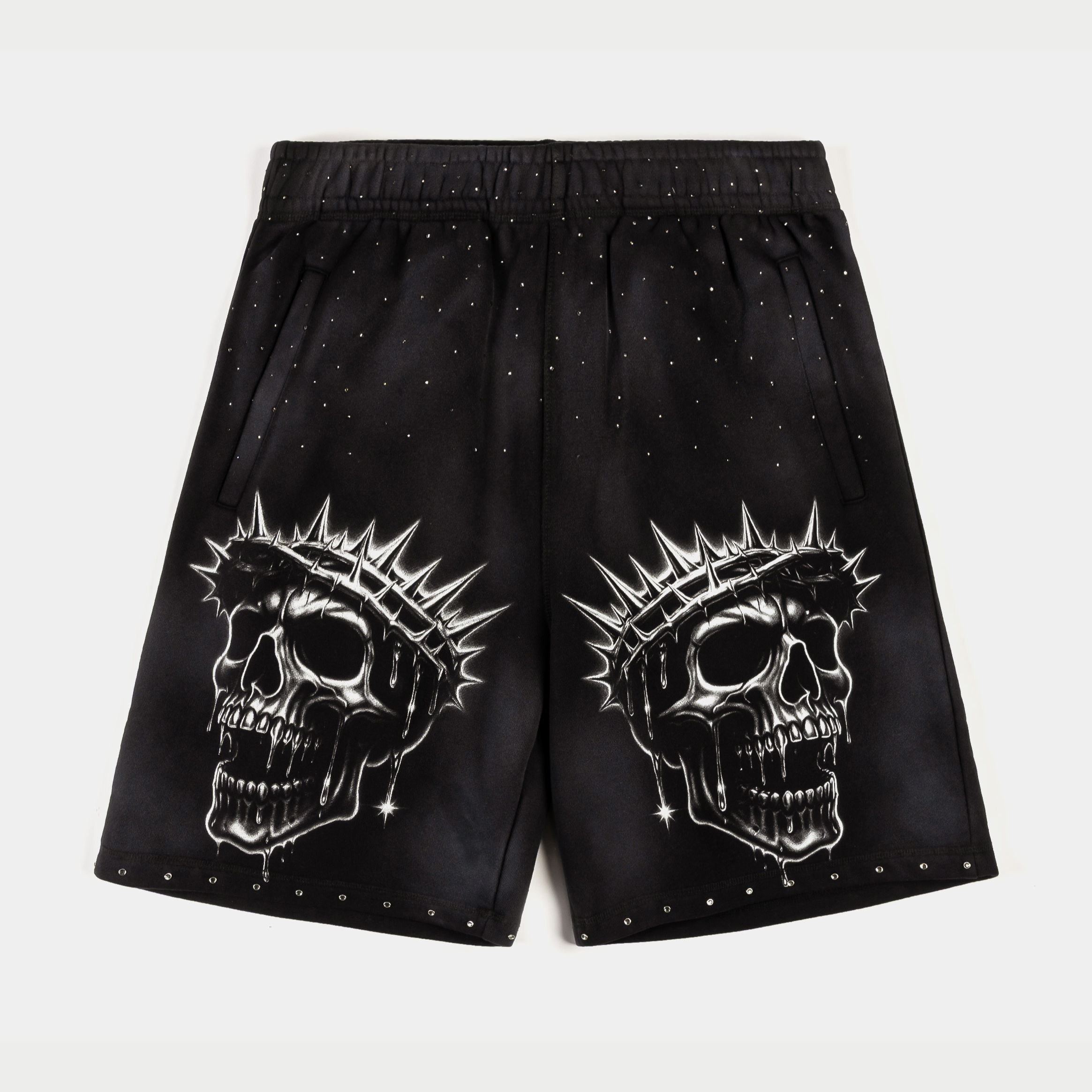 Black shorts featuring skull designs with spiked crowns and decorative studs.