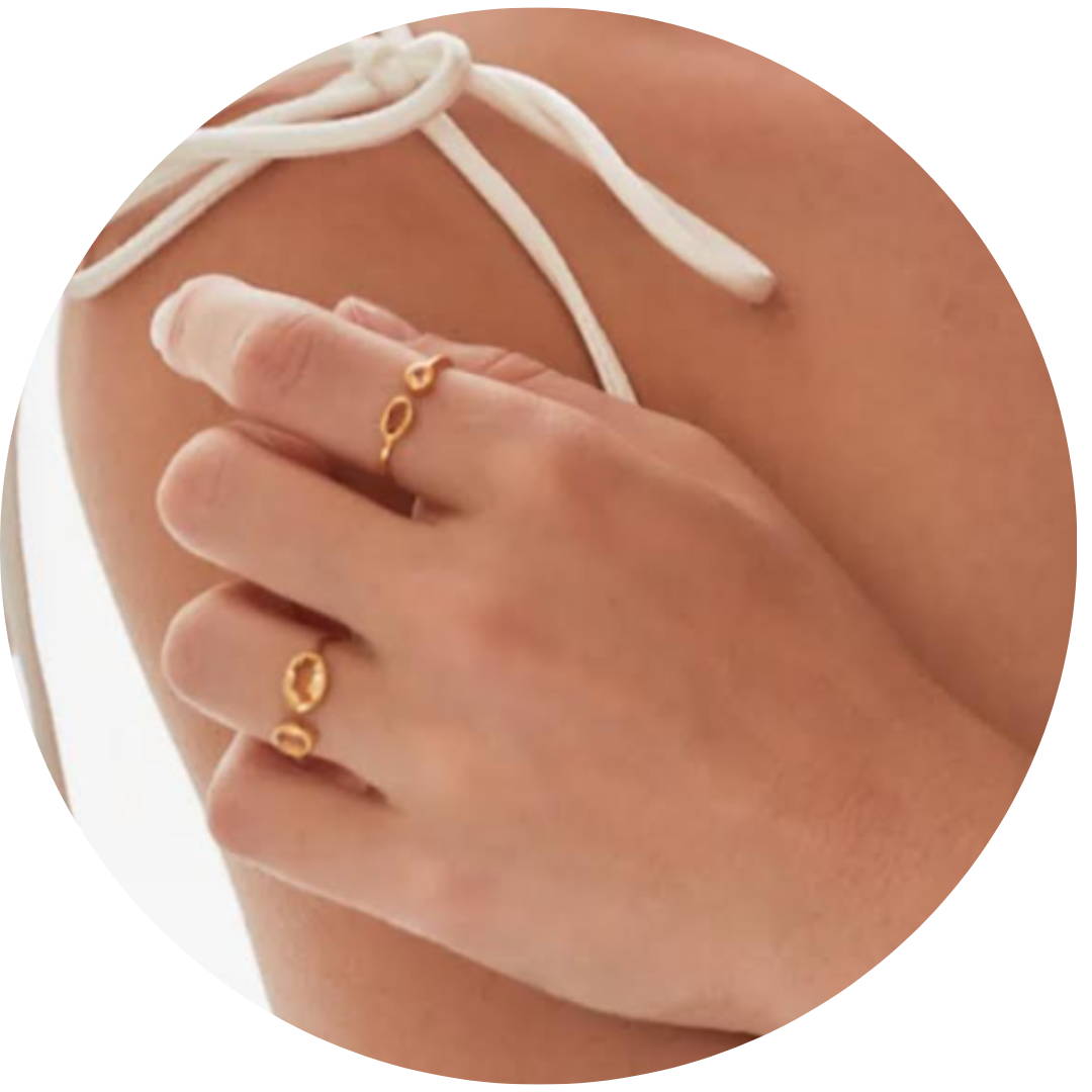 a womans hand with two gold citrine rings, 