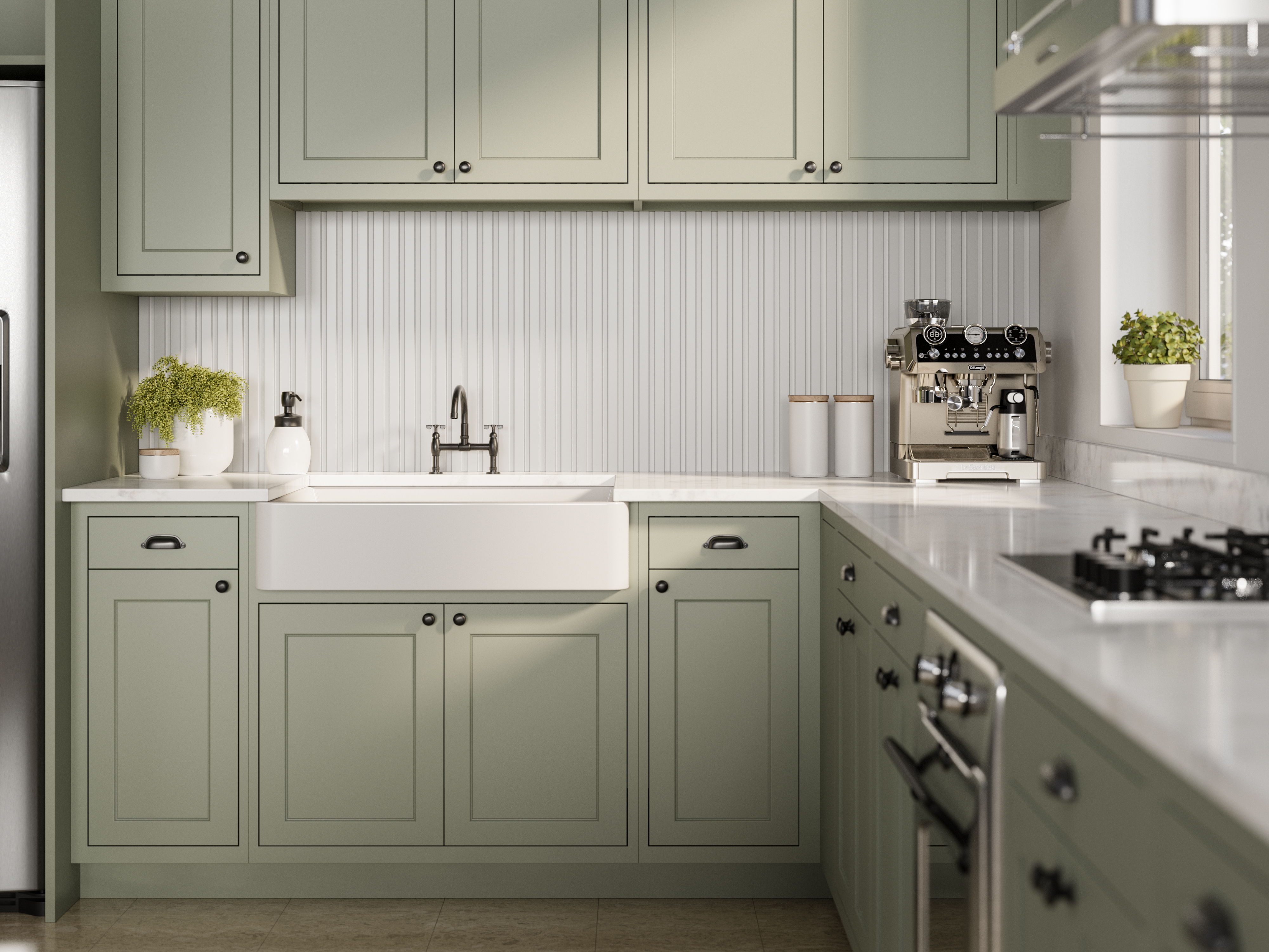 Modern kitchen with green cabinets, farmhouse sink, and stainless steel appliances.