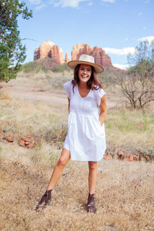 Woman standing in field wearing white Devon Dress.