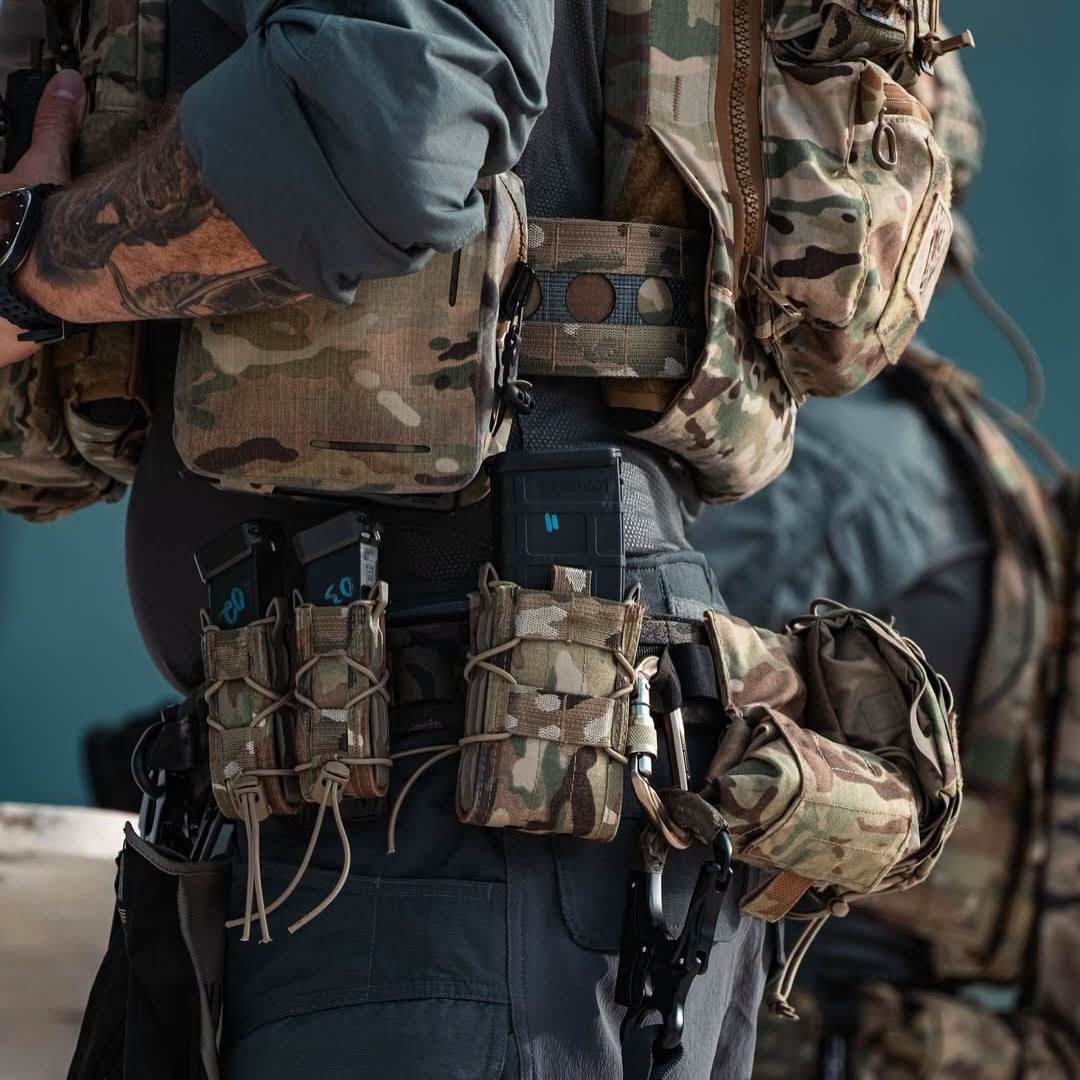 Military personnel wearing tactical gear with various equipment and pouches.