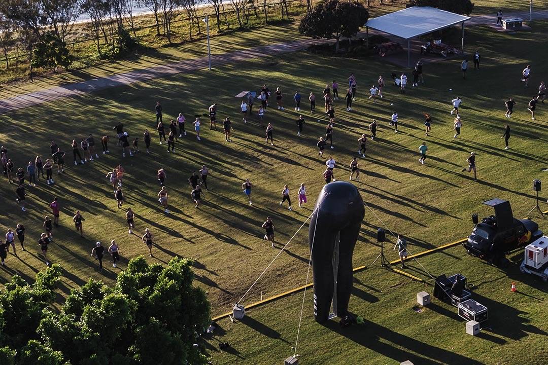 group of people working out in the park next to giant inflatable tights