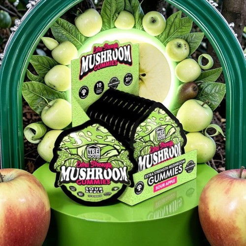 Mushroom gummies packaging surrounded by green apples.